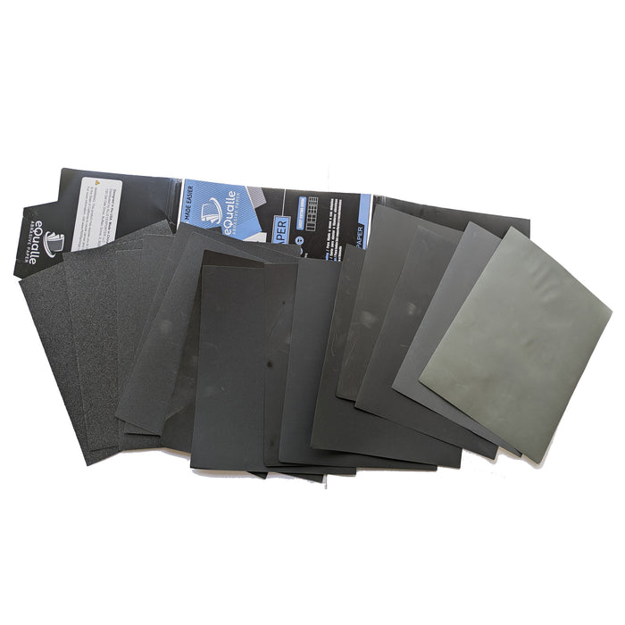 A fan of abrasive sheets beside an open blue-and-black eQualle assorted-grit package.
